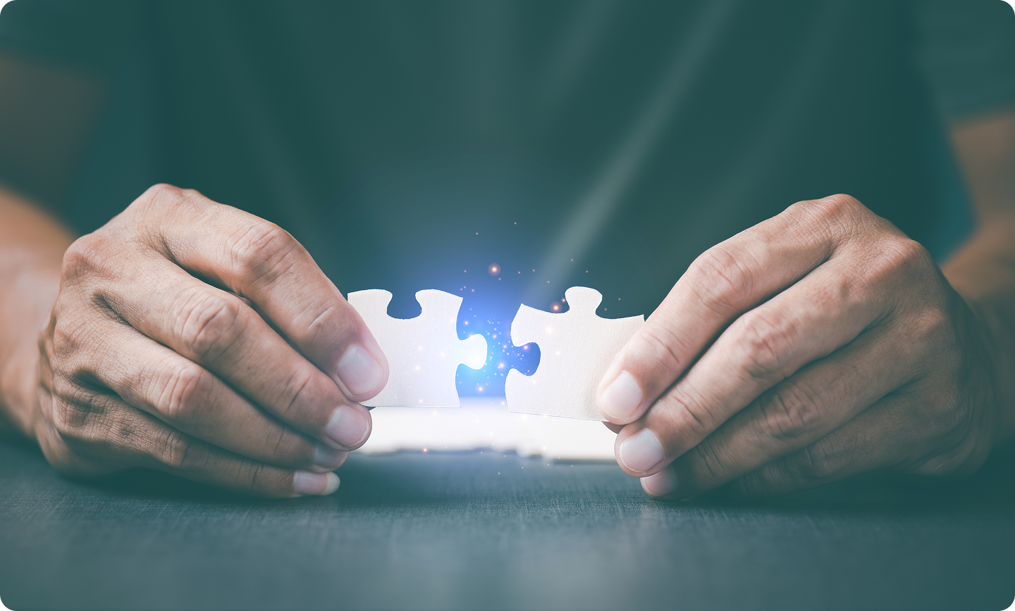Hands bringing two puzzle pieces together to represent integrations working together.